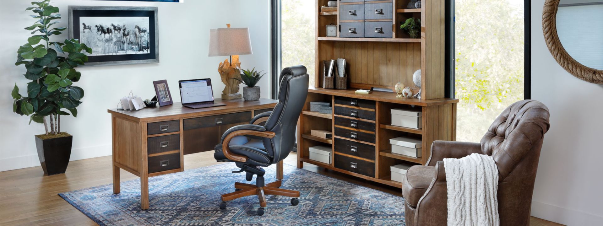 Light wood writing desk and hutch with dark wood drawers in office with office chair. 