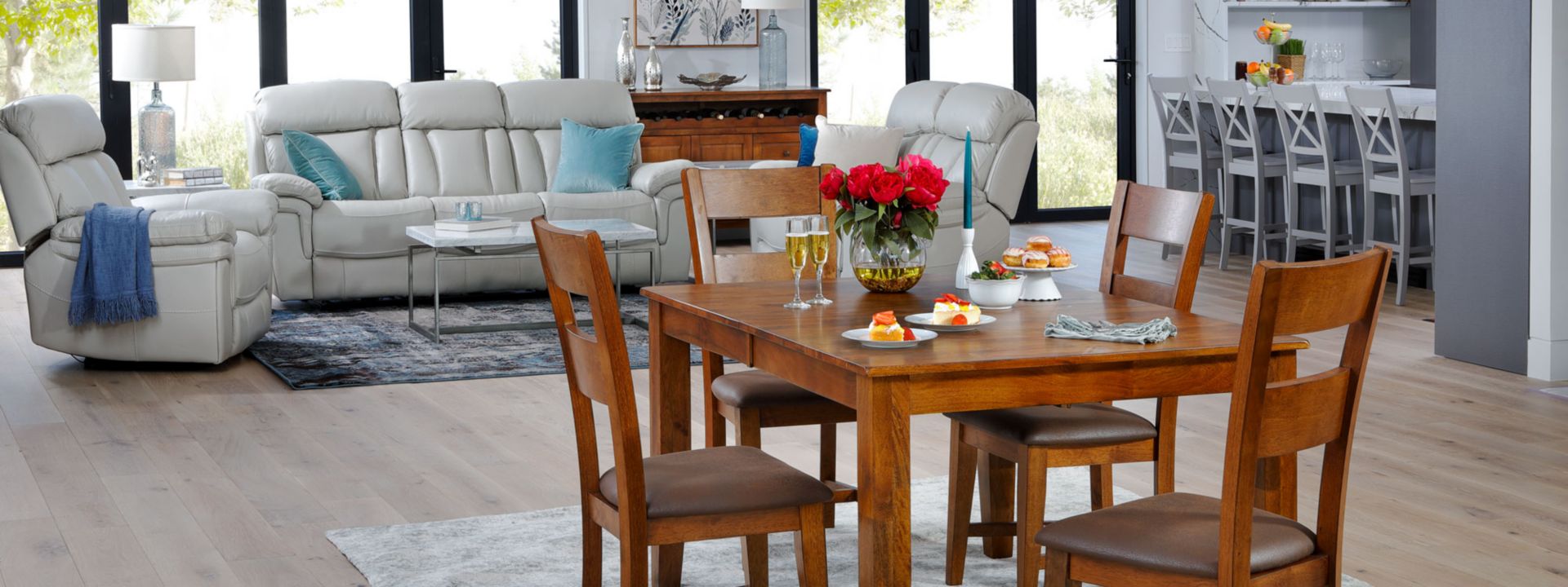 Brown wooden 4 seater dining table in open floor plan with Cream Colored Leather Sofa Set in Background 