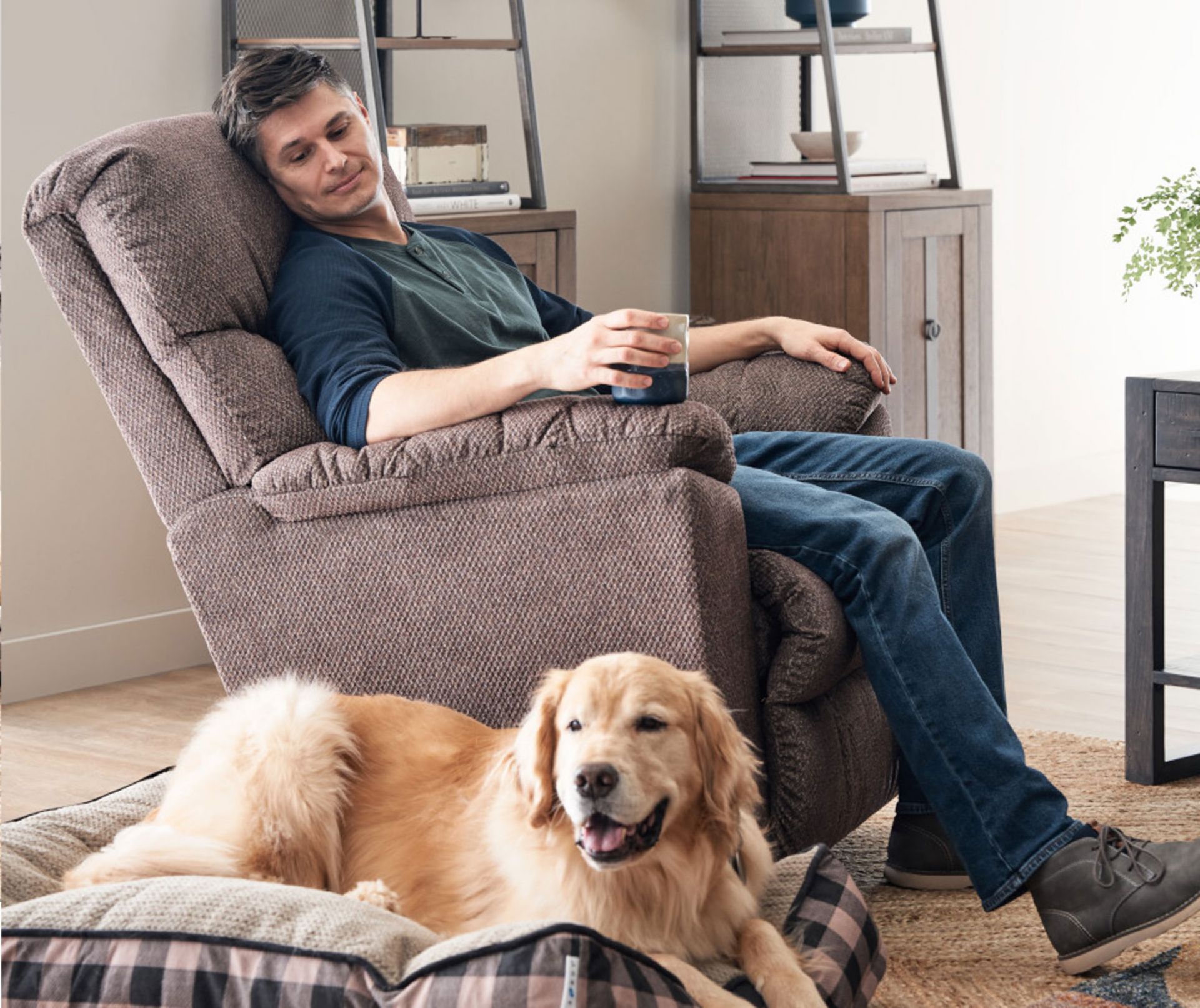 Man Reclining in Morrison Chair by LaZboy with his Golden Retriever sitting next to him