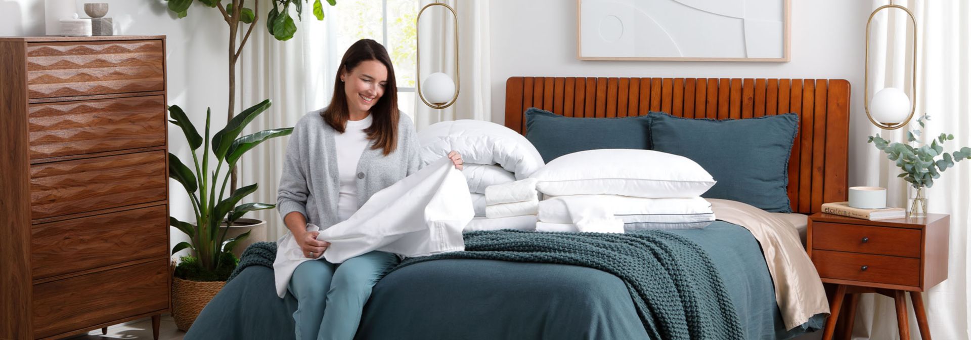 Woman putting sheets on bed. 