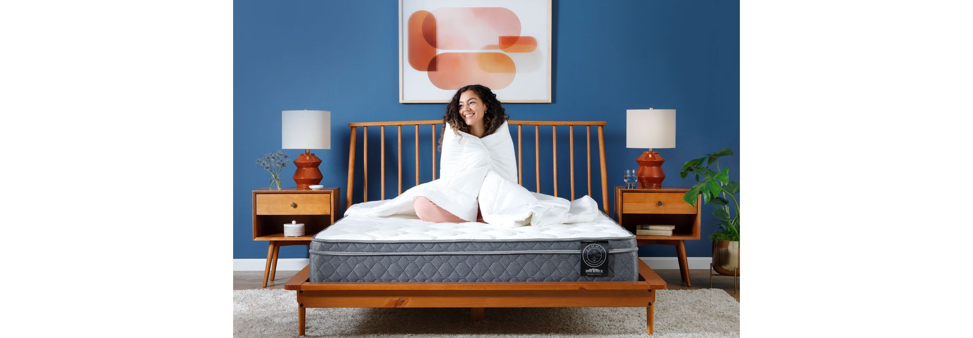 Woman sitting on Summit Mattress in Bedroom