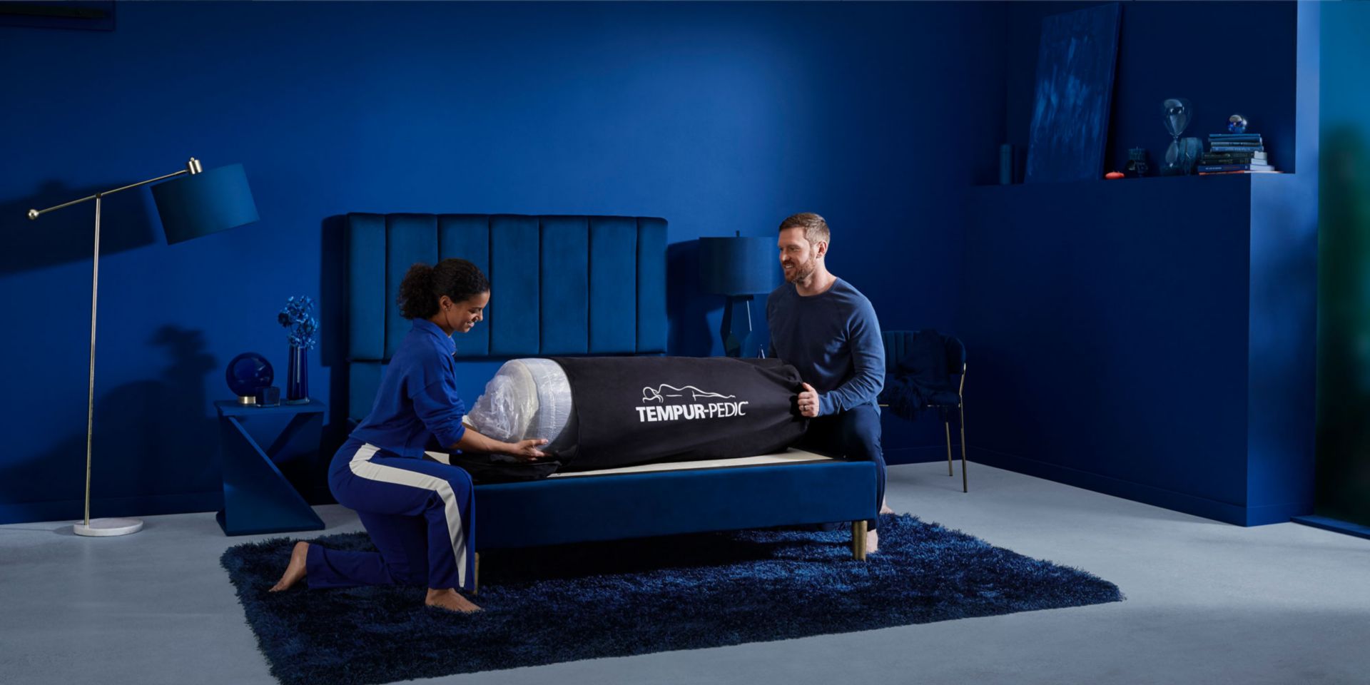 Tempur-Pedic Cloud Mattress. Rolled up on top of bed frame being unpacked by couple.