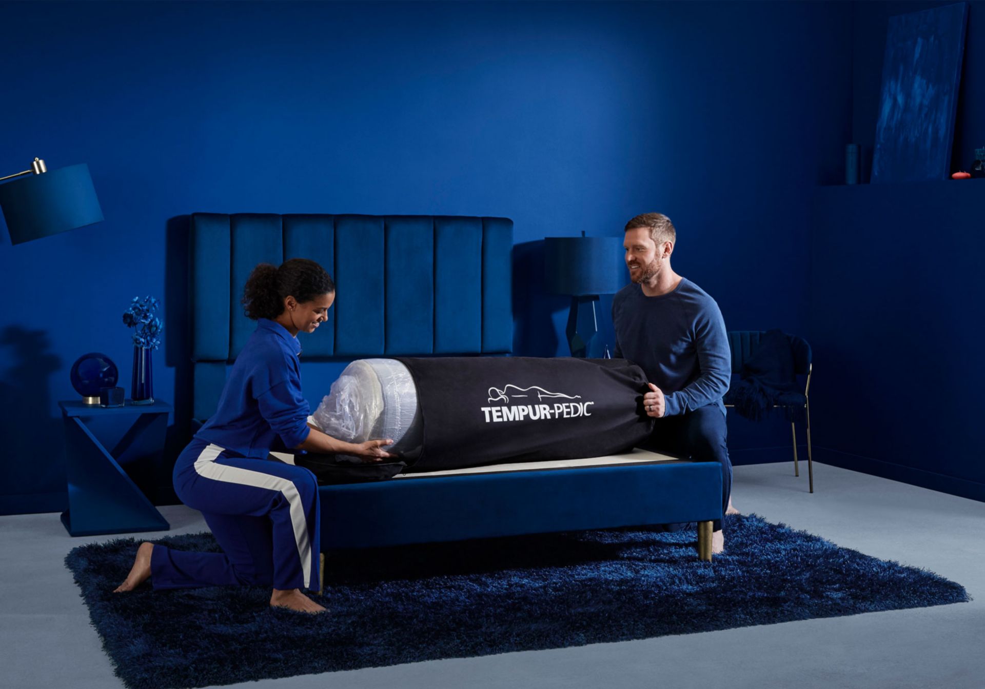 Tempur-Pedic Cloud Mattress. Rolled up on top of bed frame being unpacked by couple.