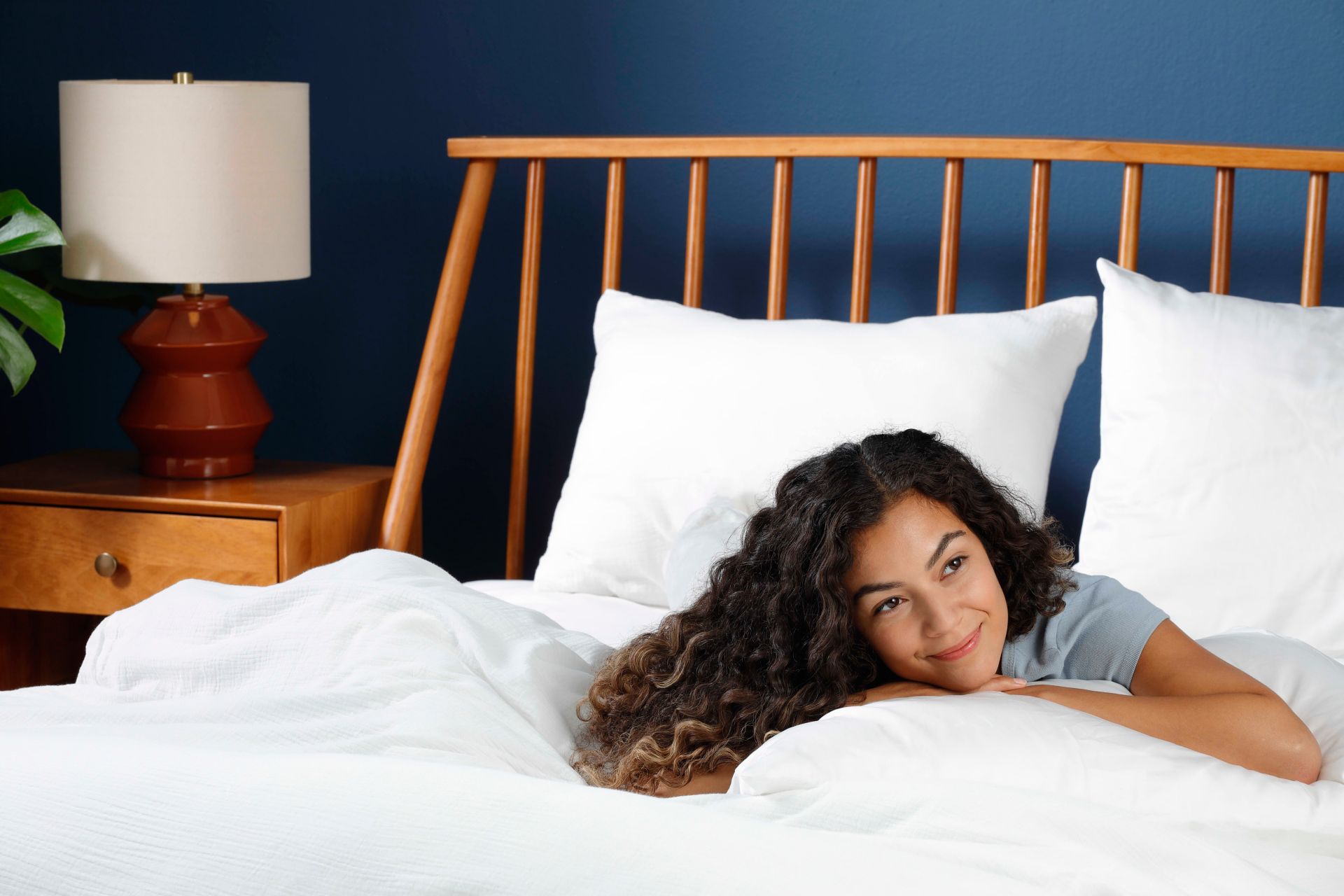 young woman laying on her bed under the covers