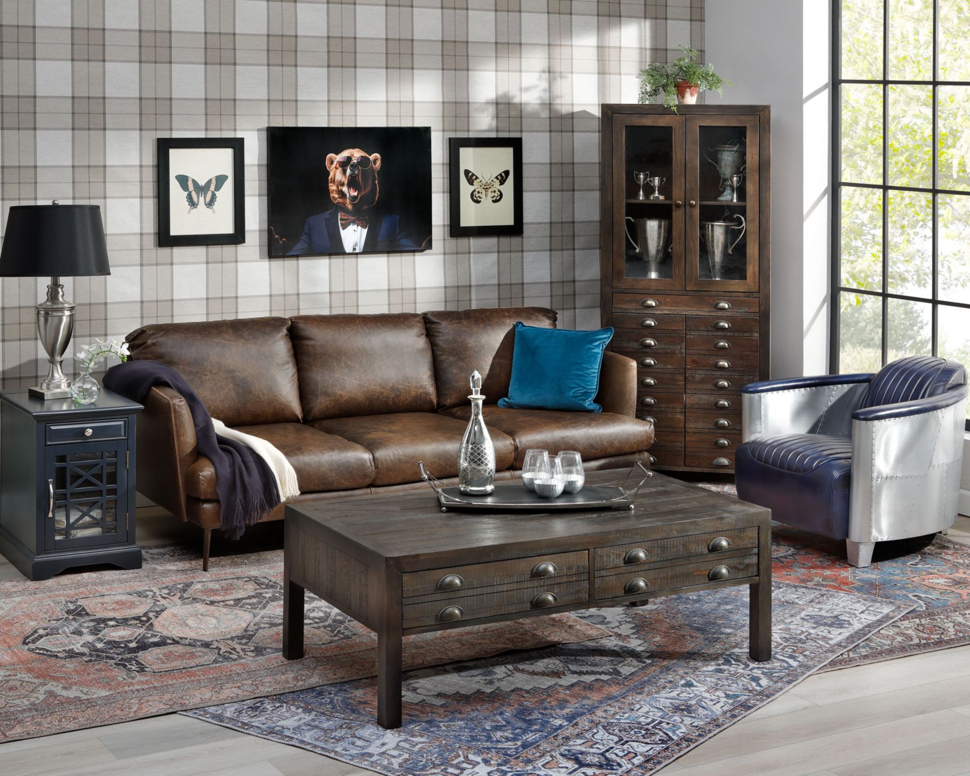 Brown Leather Sofa with navy windowed side table and apothecary style shelves and coffee table. 