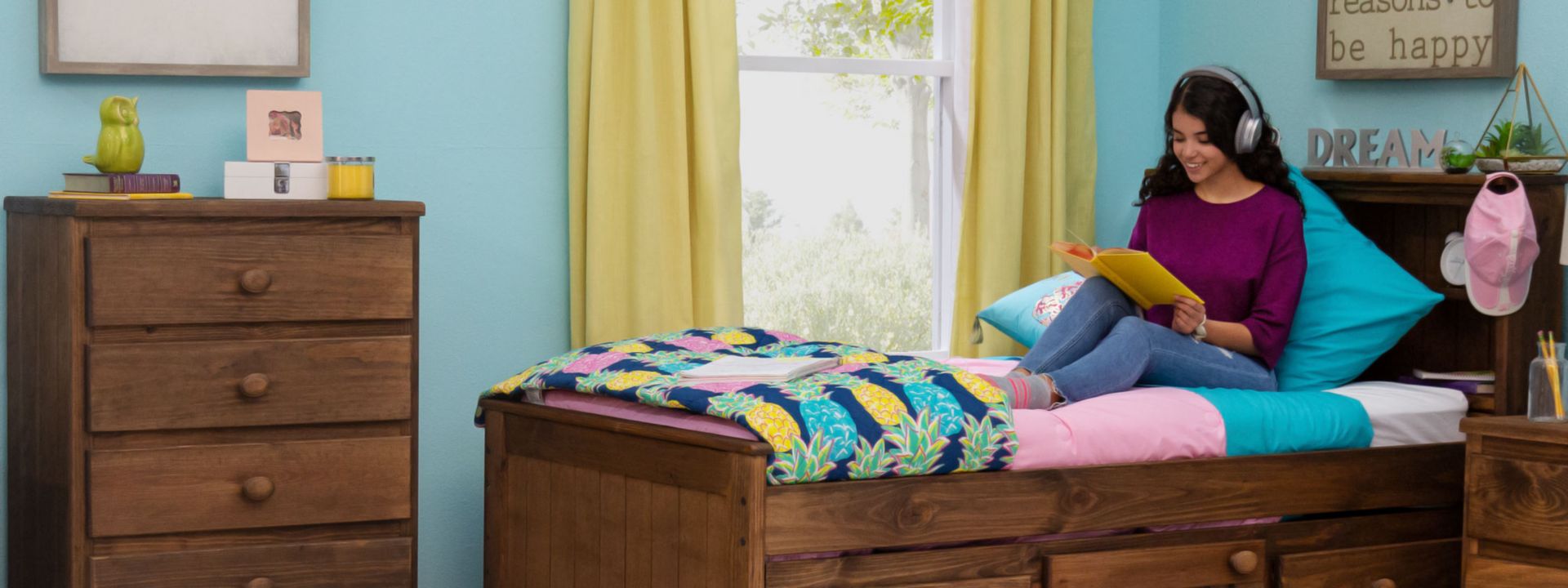 Student Sitting on Bookcase Bed with Headphones and Notebook