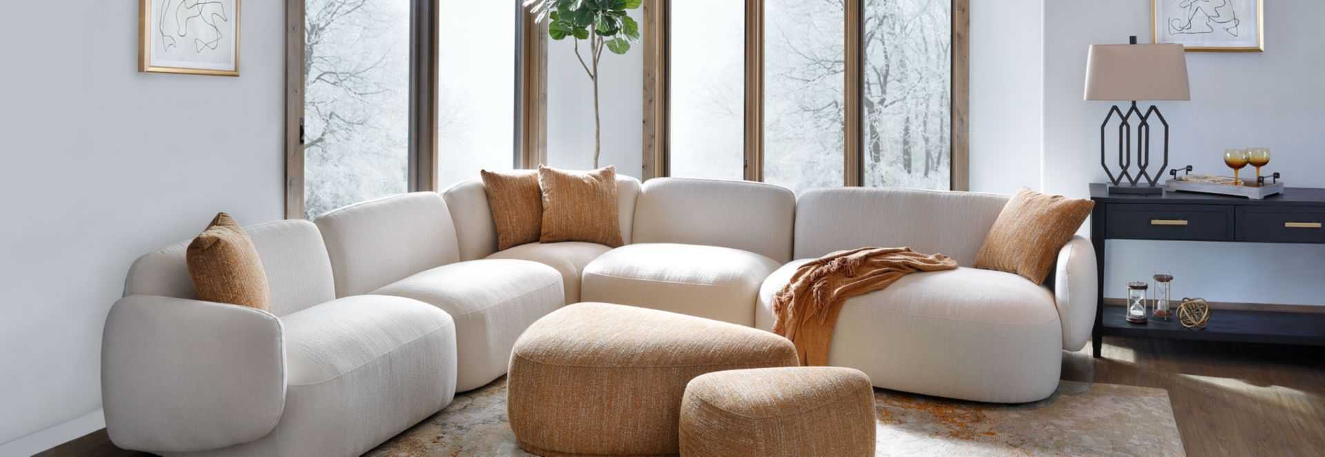 White curved sectional with gold pillows and ottomans
