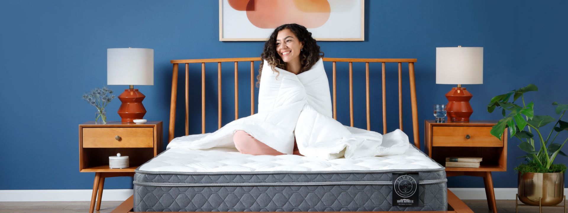 Woman sitting on Summit Mattress in Bedroom